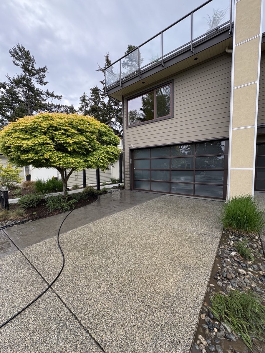 Freshly washed exposed-aggregate driveway in front of a garage