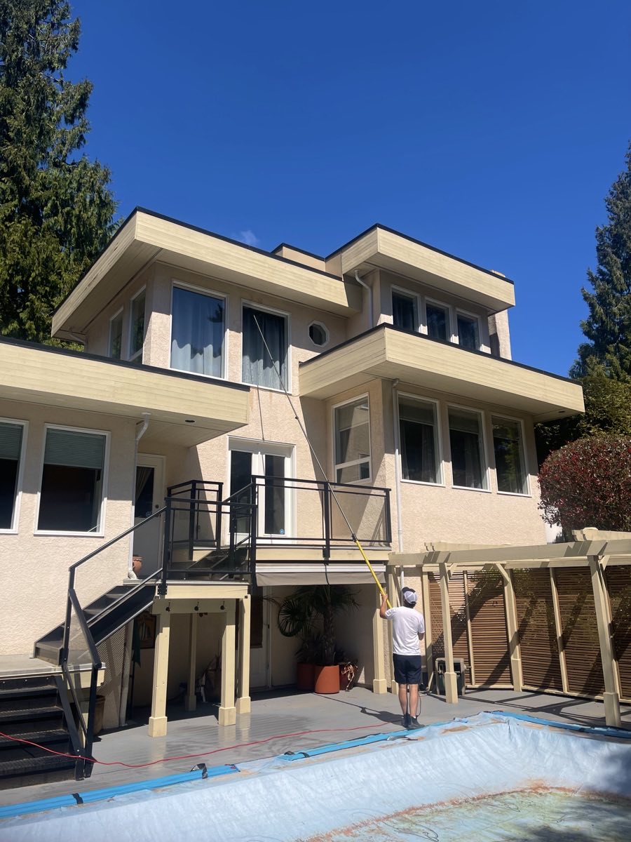 Cleaning second-storey windows with a water-fed pole at a Greater Victoria home